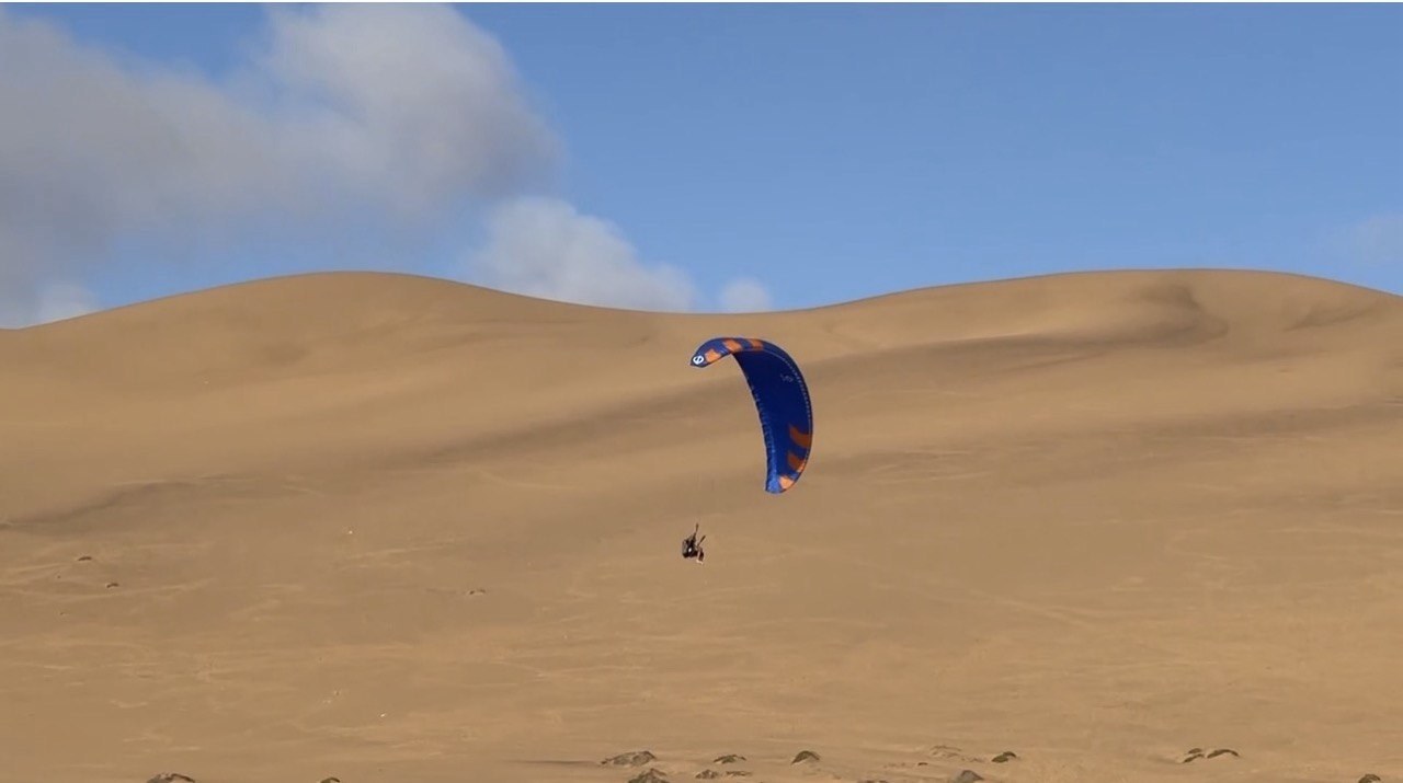 Paraglider flying above the coast