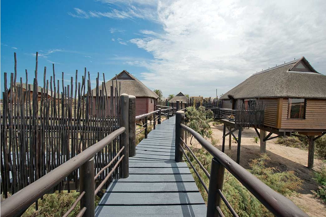 Walkway between raised bungalows at The Stiltz