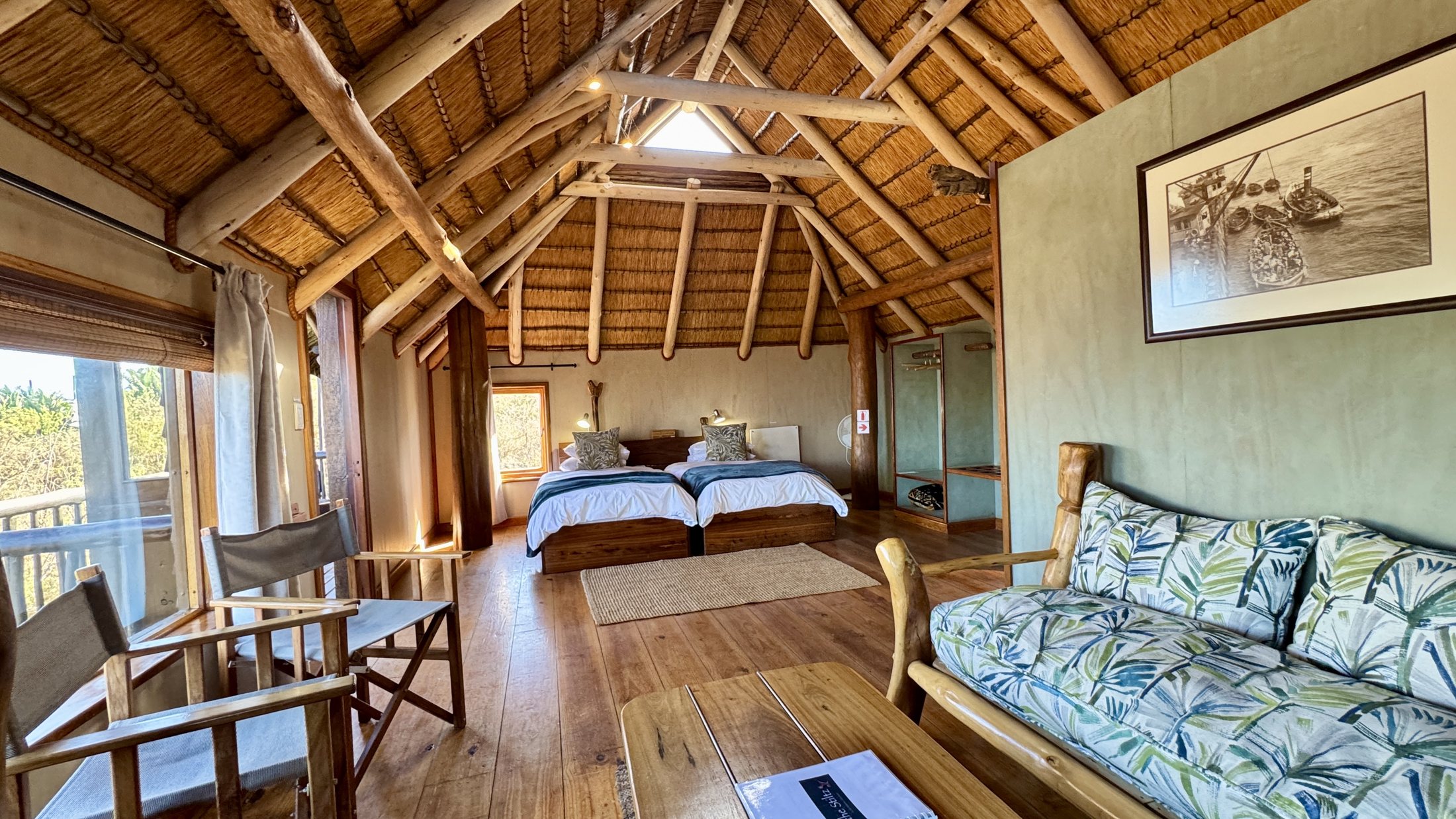 Twin bungalow bedroom with a lounge corner and timber ceiling