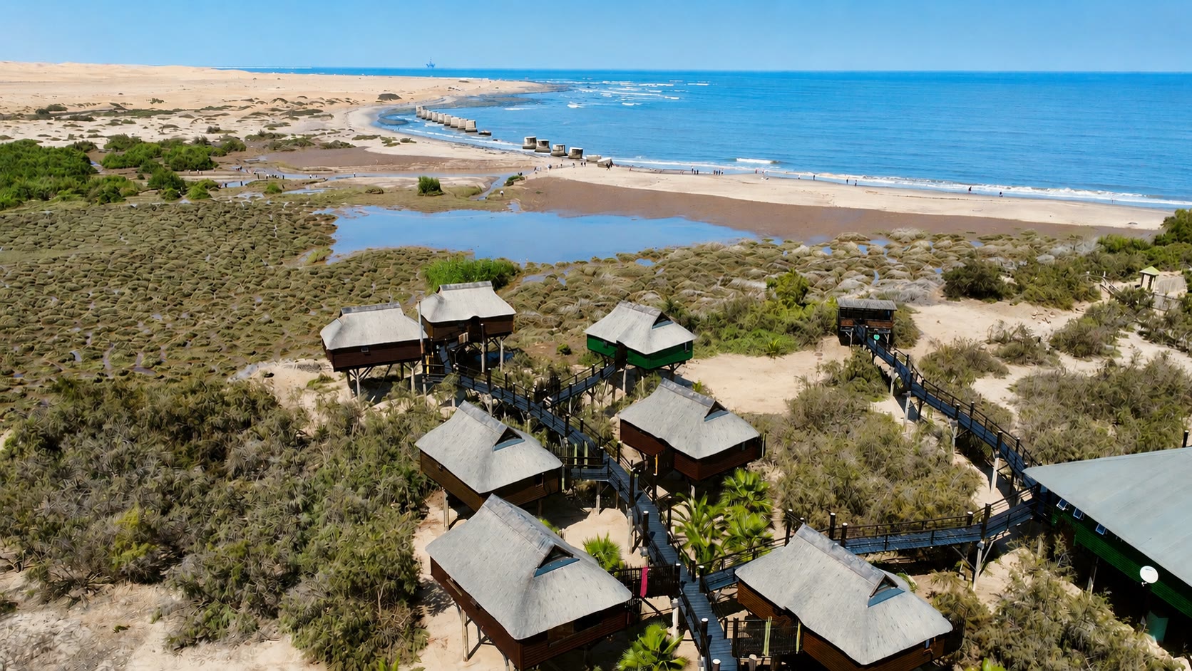 Aerial view of The Stiltz between the lagoon, dunes and Atlantic Ocean