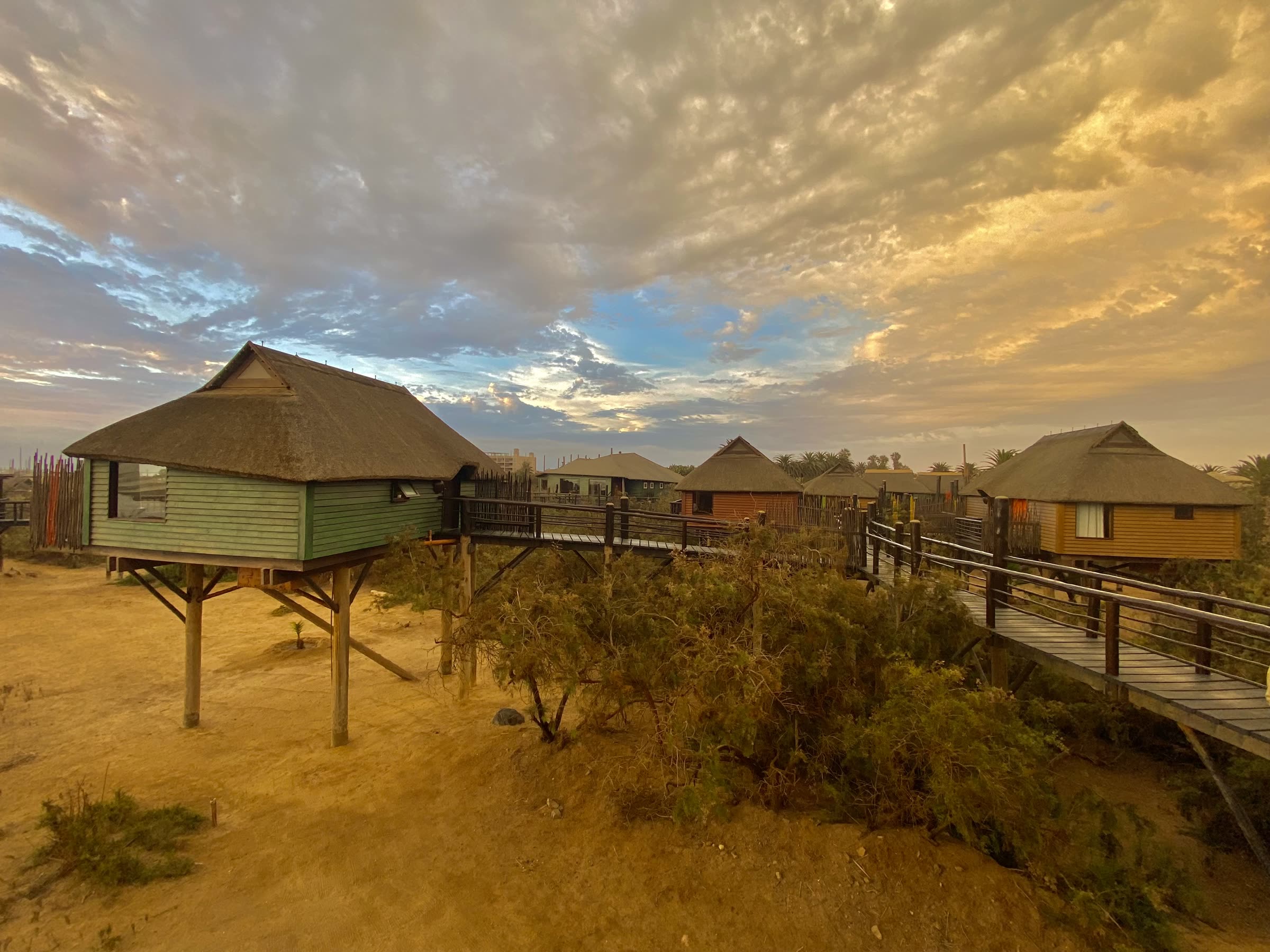 The Stiltz bungalows under a cloudy sunset sky