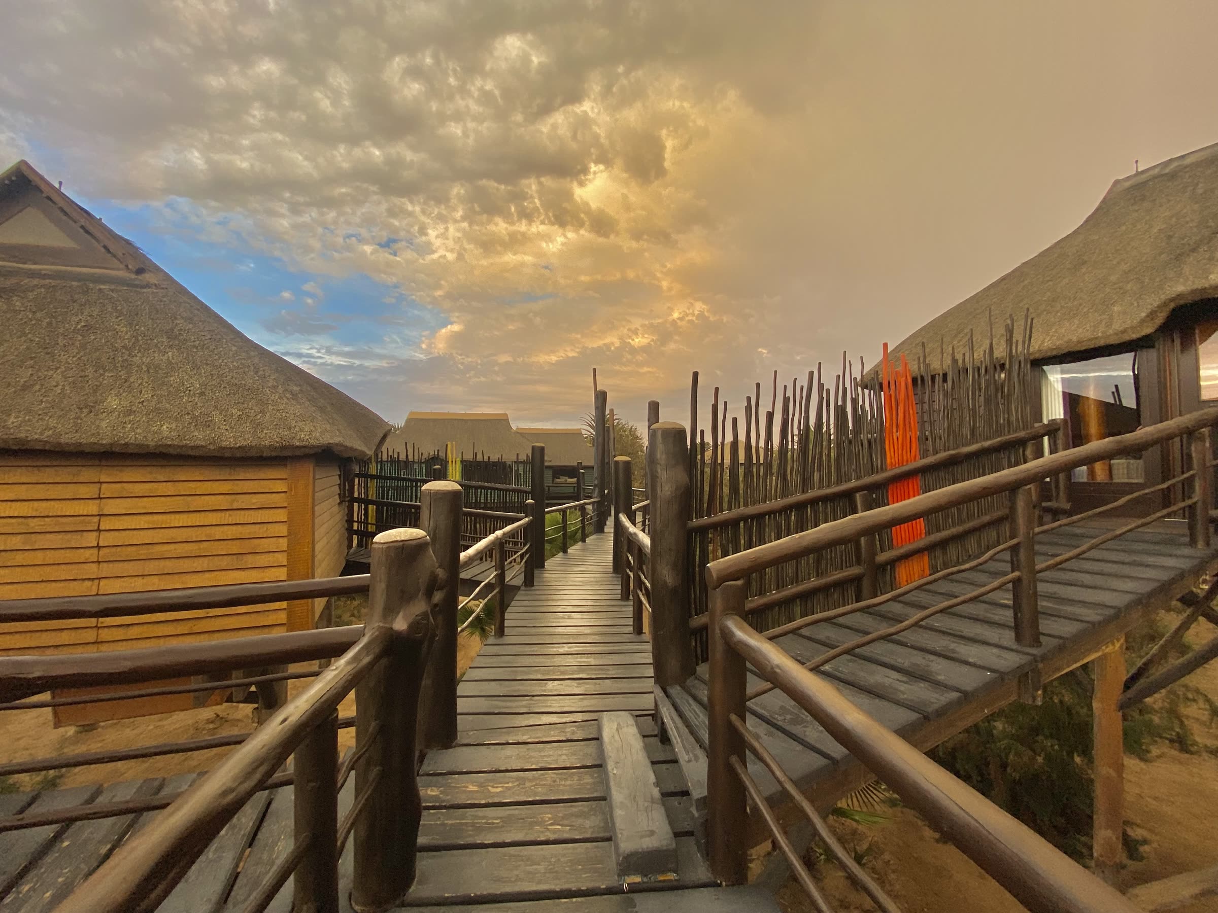Raised walkway between bungalows at sunset