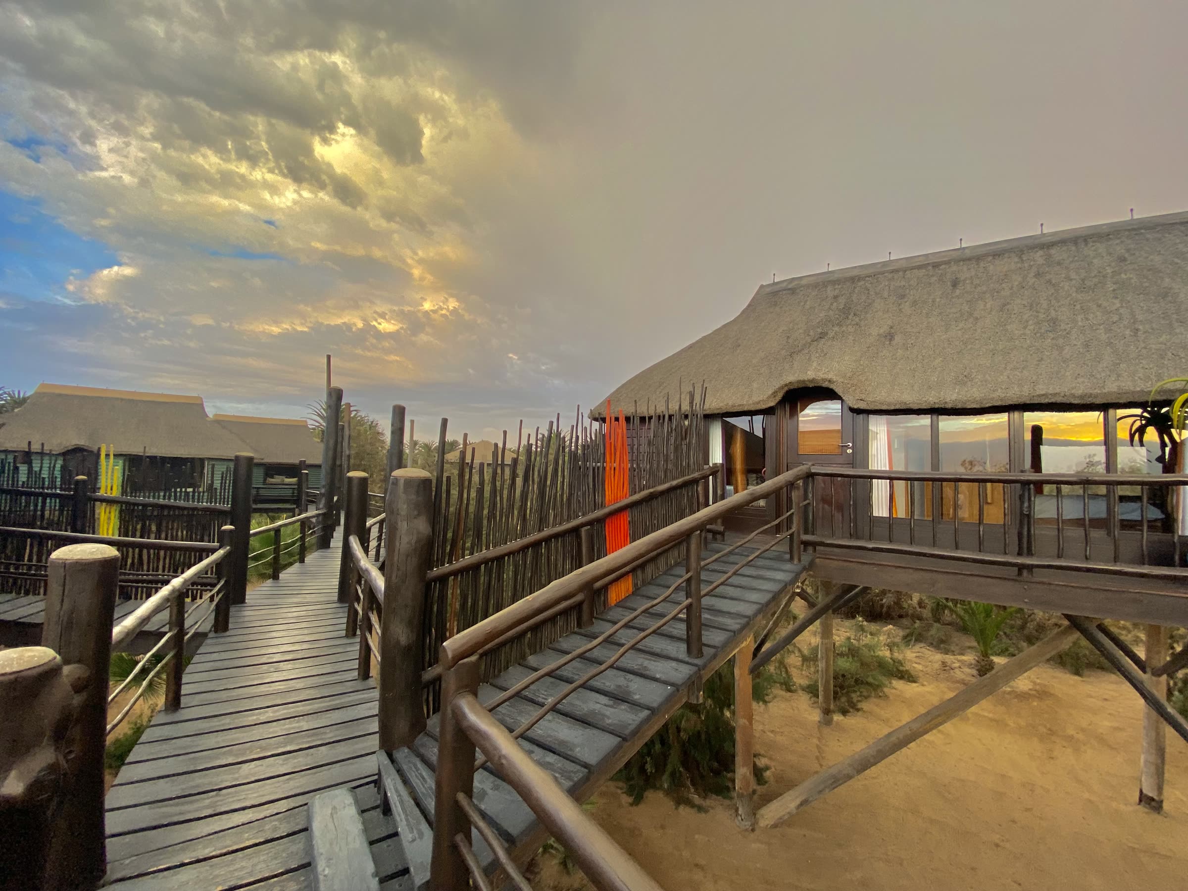Raised walkway leading to a bungalow at sunset