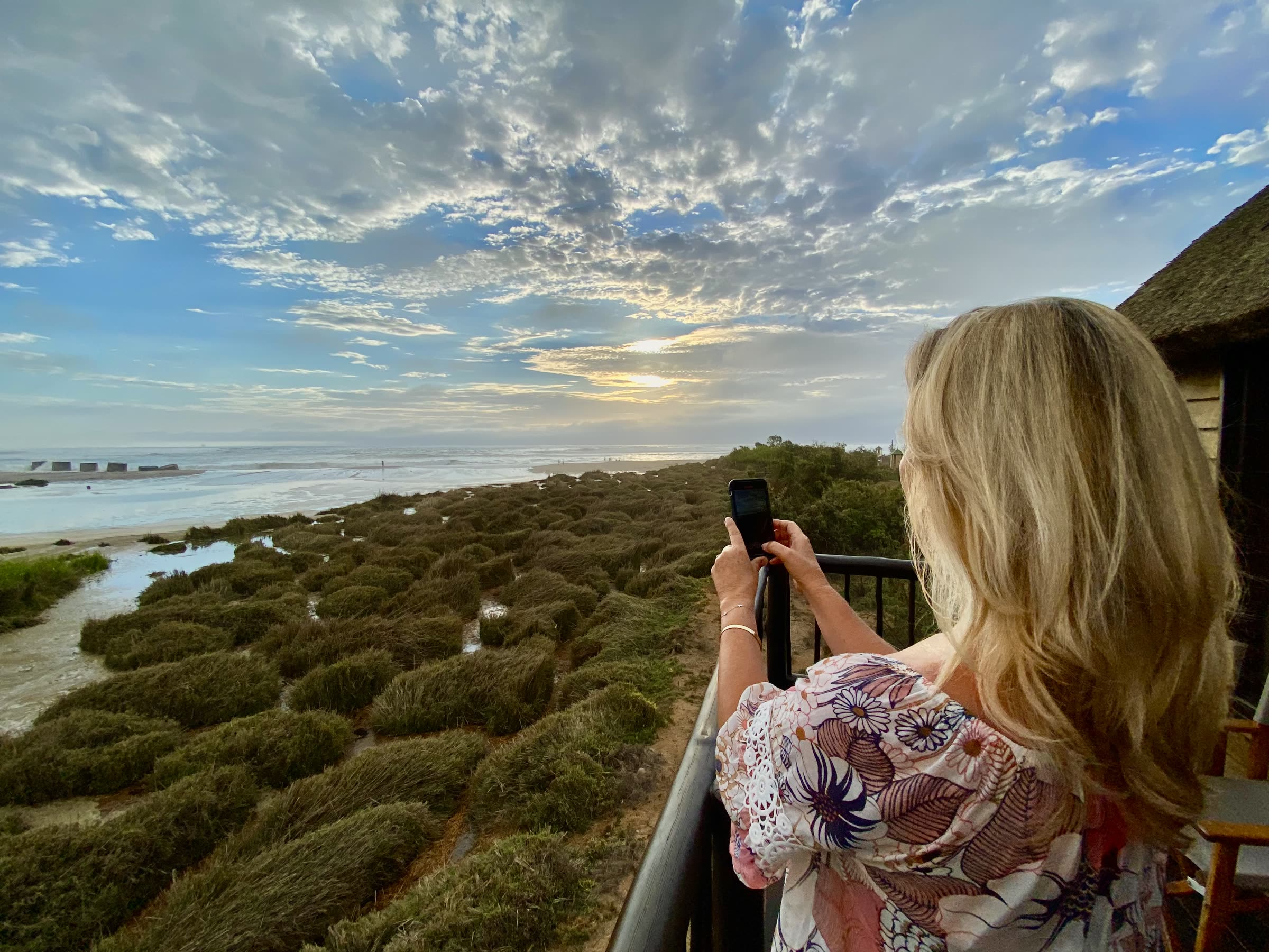 Guest photographing the lagoon from a villa balcony